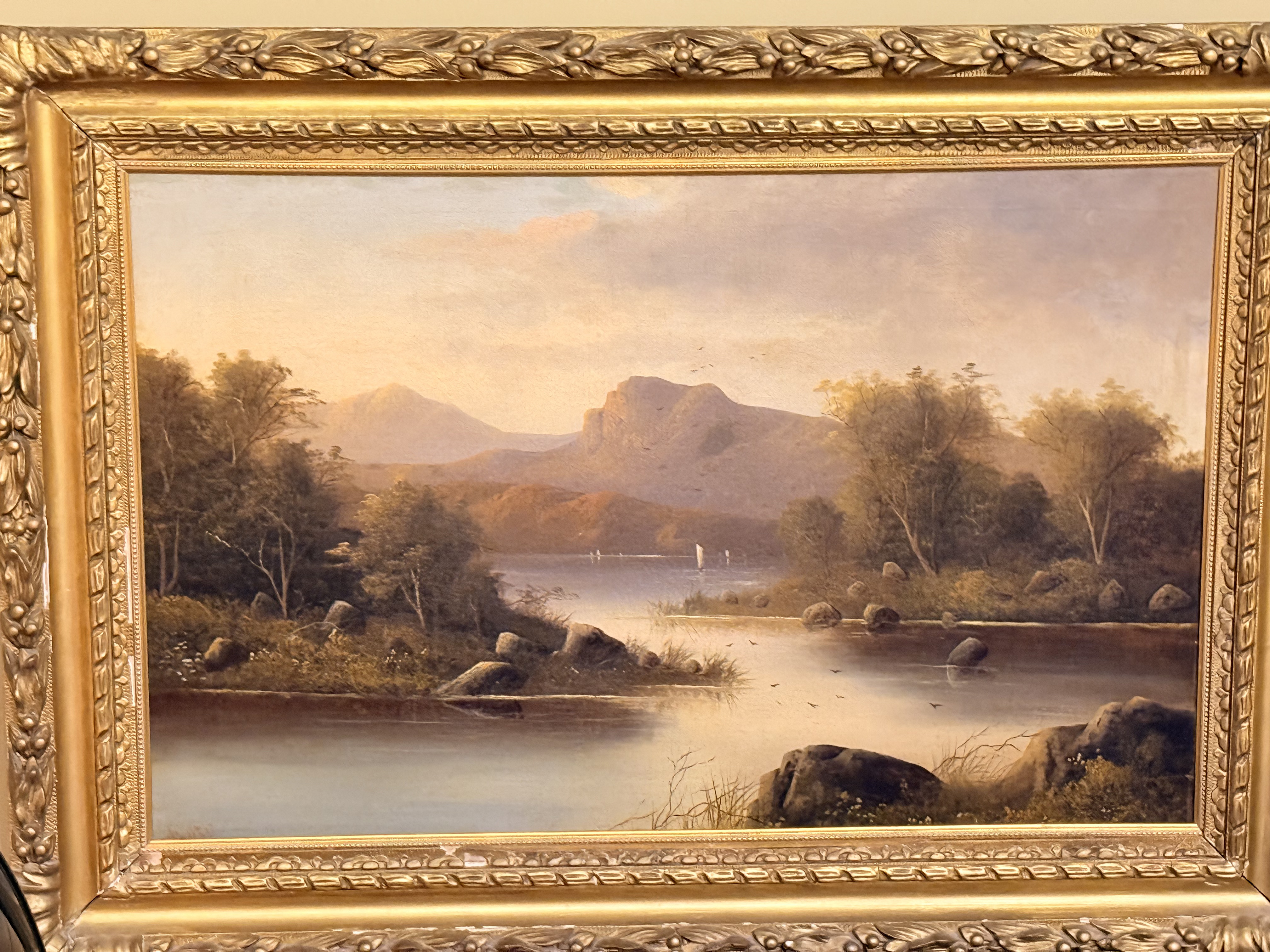 Painting of a quiet lake beneath mountains.