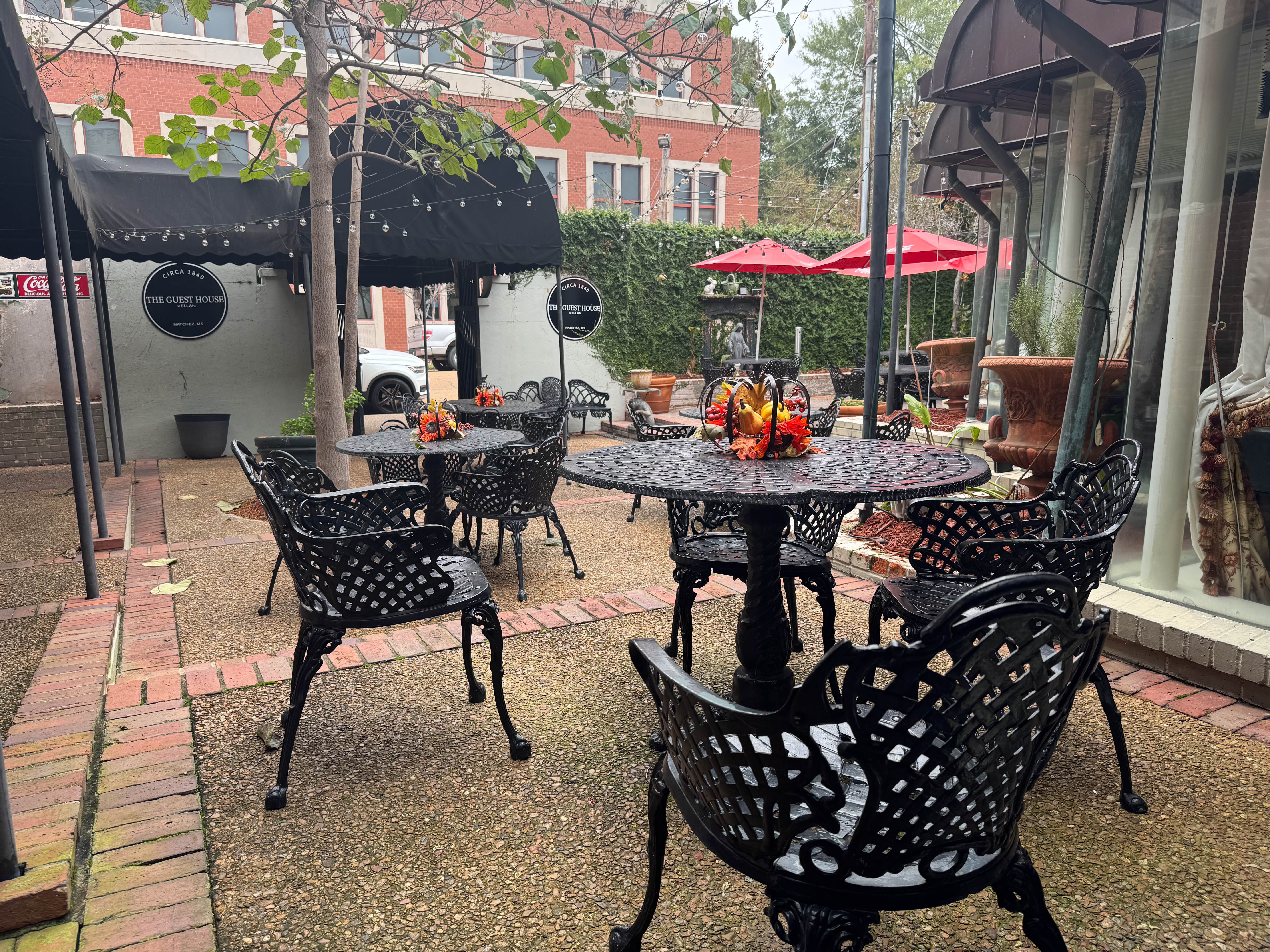 Cast-iron tables and chairs in the brick courtyard of The Guest House.