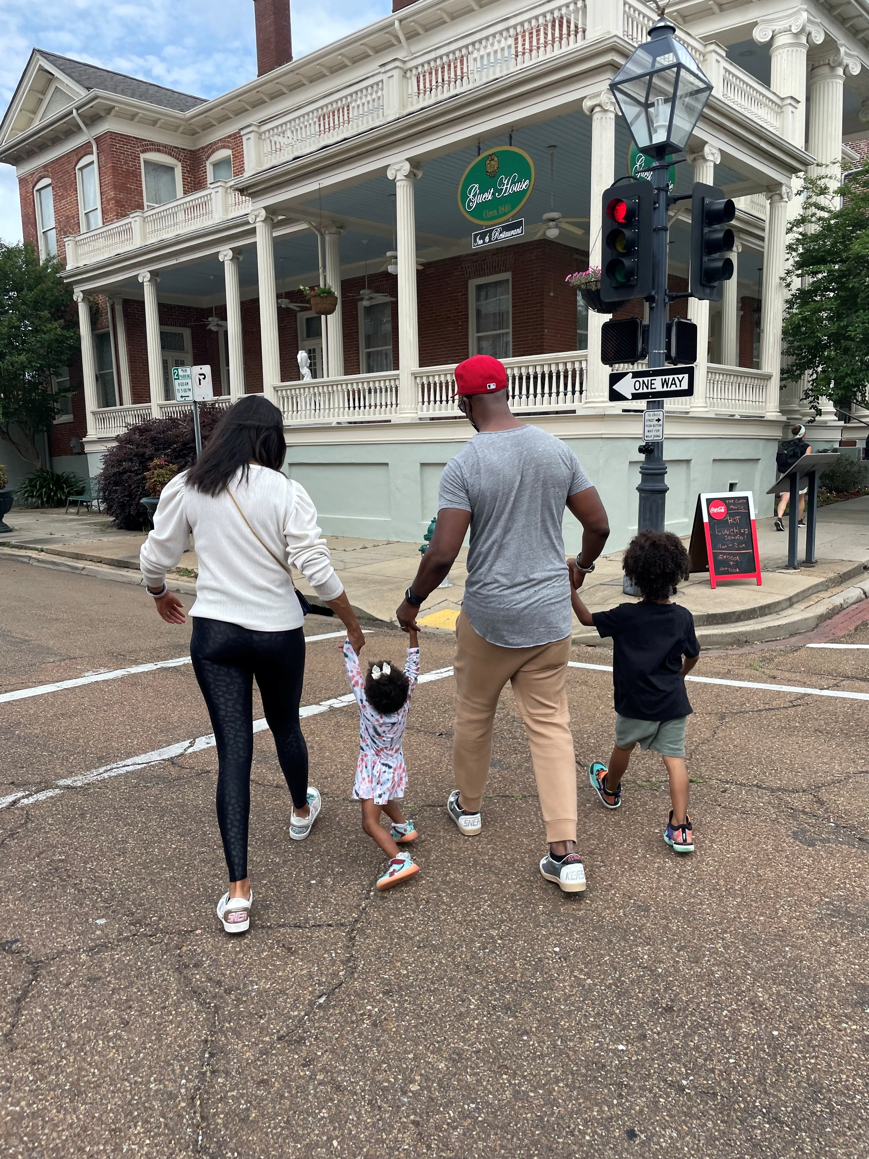 The Clinton family walking toward The Guest House from across the street on a summer morning.