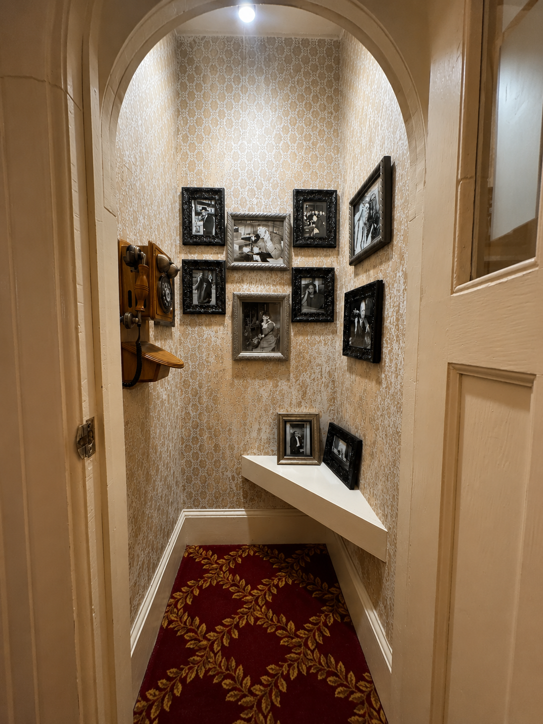 A vintage wooden telephone booth tucked into the mansion hallway, glowing with a single Edison bulb. - image 3
