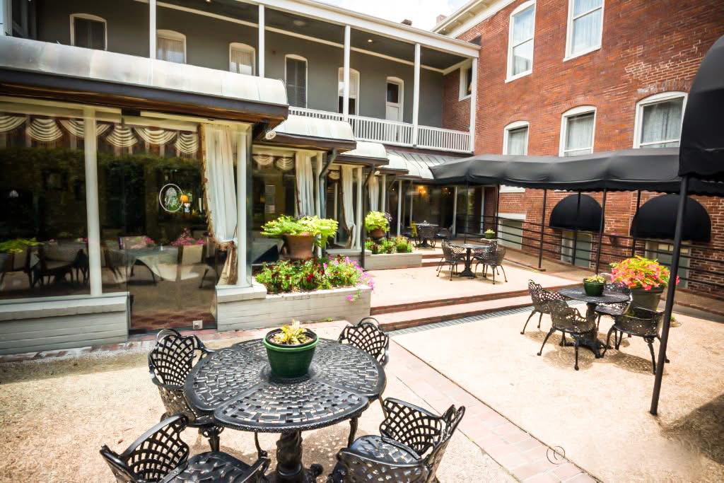 The restaurant courtyard, cast-iron tables set beside the dining room windows.